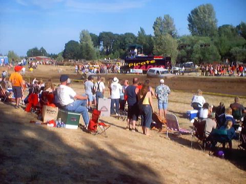 1976 Ford F-100 - Spectators gather at a mud run event, with a truck visible in the distance.