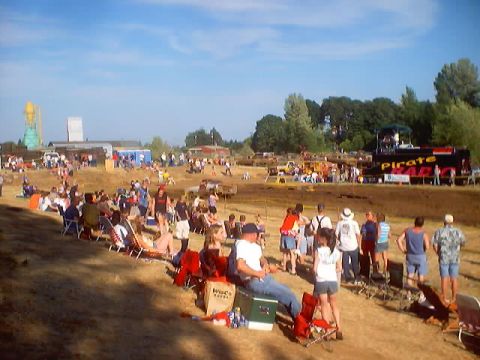 1976 Ford F-100 - Spectators gather at a mud run event, with a prominent truck in the background.