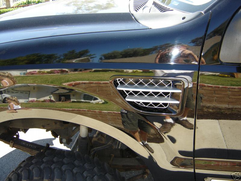 Chrome side vent on the fender of a dark vehicle