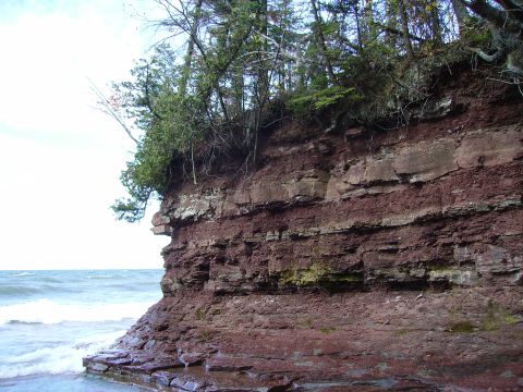 2000 Chevrolet Tahoe - Layered rock formation on a cliff overlooking the water, with trees growing on top.