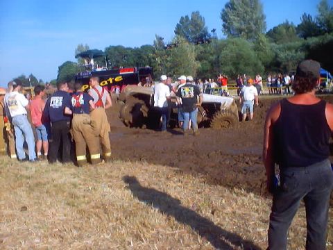 1976 Ford F-100 - A crowd gathers to watch a mud bogging competition where a vehicle is stuck in the thick mud.