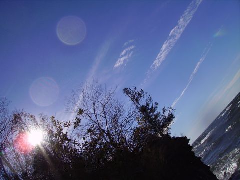 2000 Chevrolet Tahoe - Sky scene with clouds and trees, sun glare visible.