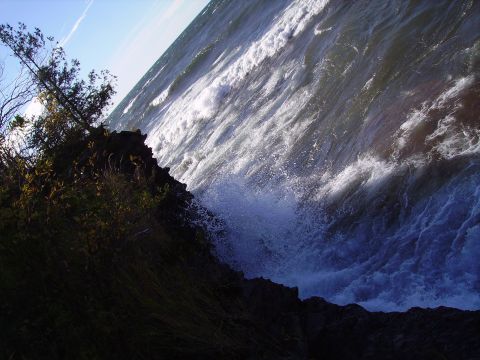 2000 Chevrolet Tahoe - Waves crash against rocks during a storm. The Supermotors.net logo is visible in the corner.