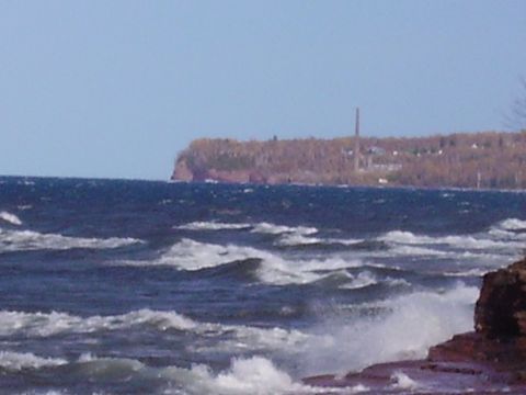 2000 Chevrolet Tahoe - A scenic view of choppy water against a distant cliffside, with a smokestack visible on the horizon.