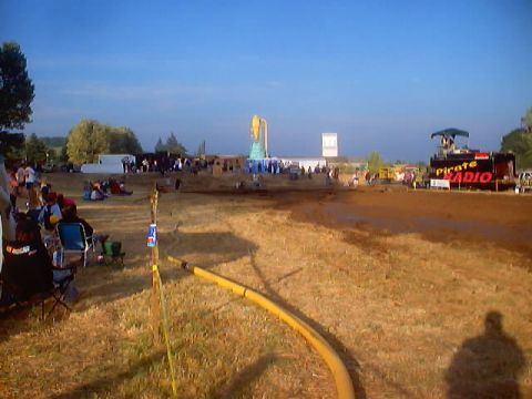 1976 Ford F-100 - An outdoor event with spectators and a 'Pirate Radio' stage is visible under a clear blue sky.
