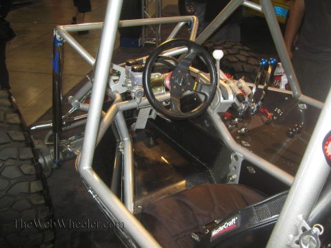 1990 Ford Bronco - Interior of a tube-chassis off-road buggy showing the steering wheel, multiple shift levers and a fabric race seat.
