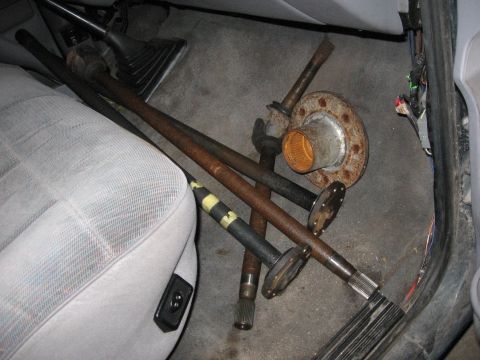 1974 Ford F-100 - Axle shafts and a hub assembly are stored inside a vehicle's cabin.