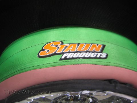 1990 Ford Bronco - green fabric band printed with the orange and white Staun Products logo wraps a tire mounted on a chrome wheel.