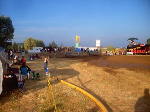 1976 Ford F-100 - Spectators watch a mud bog event with a Pirate Radio stage set up in the background.