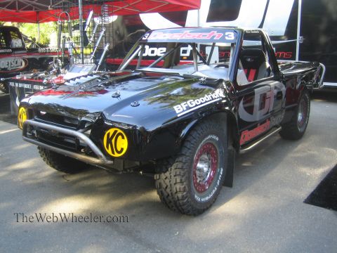 1990 Ford Bronco - black Doetsch Tech number 3 off-road trophy truck with yellow KC light covers and BFGoodrich tires sits on a trailer.