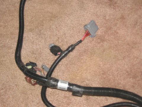 1991 Ford Bronco - A close-up view of an automotive wiring harness, showing various connectors and a label.