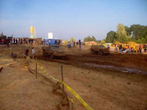 1976 Ford F-100 - Trucks compete in a mud bogging event with a crowd gathered to watch the action.