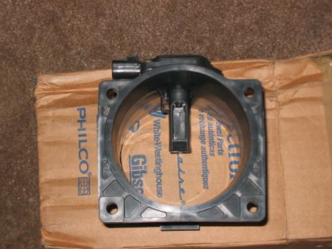 1991 Ford Bronco - A black mass air flow sensor is shown resting on a cardboard box that displays branding from Philco and White-Westinghouse.
