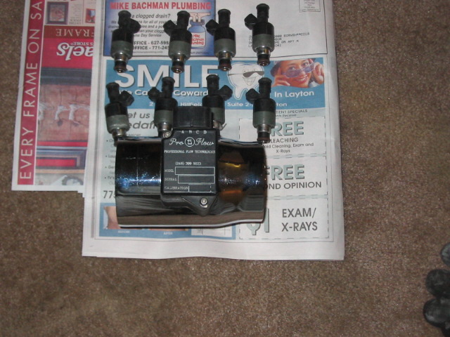 Eight fuel injectors mounted on a chrome fuel rail with 'Pro-Flow' label