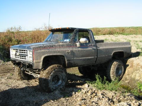 1990 Ford Bronco - This lifted pickup truck is covered in mud after an off-road excursion.