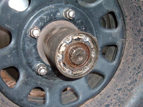1993 Ford Bronco - This image shows a close-up view of a vehicle's wheel hub assembly, including the lug nuts and the locking mechanism.