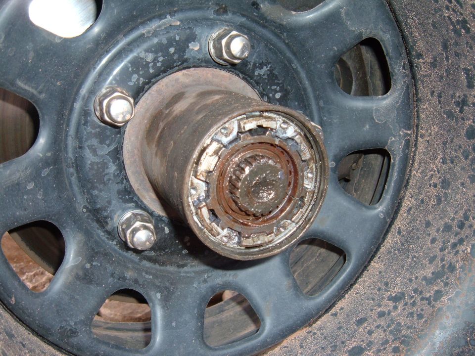 Black steel wheel with locking hub removed showing chewed hub lock ring and splined axle