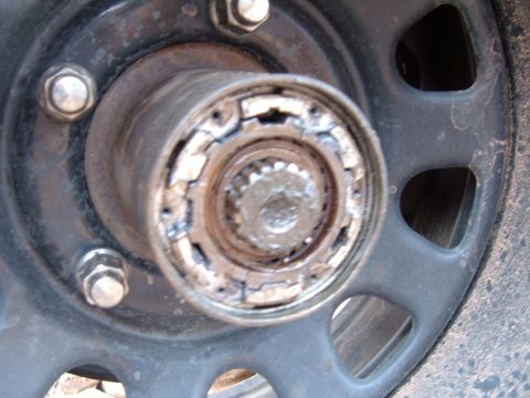1993 Ford Bronco - A close-up view of a wheel hub assembly, showing rust and wear on the metal components.