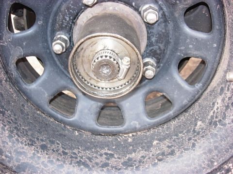 1993 Ford Bronco - A close-up view of a vehicle's wheel hub and lug nuts, showing mechanical detail.