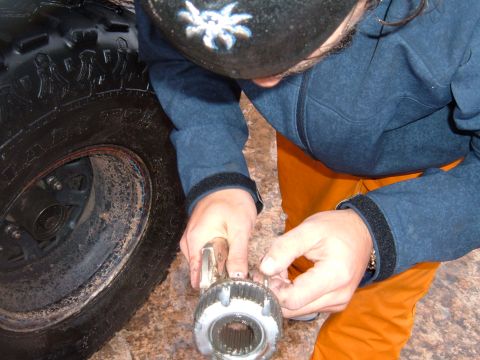 1993 Ford Bronco - A person is shown working on a vehicle part next to a large tire, with a watermark for Supermotors.net visible.