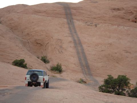 1993 Ford Bronco - Ford Bronco navigates a challenging off-road path through a desert landscape.