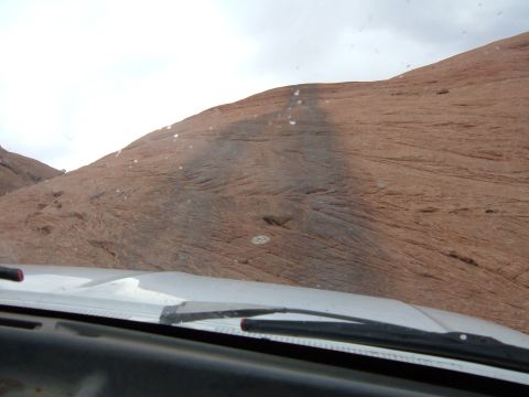 1993 Ford Bronco - View from inside a vehicle driving on a rocky terrain, with the dashboard and windshield wipers visible.