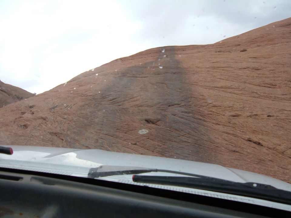 Dashboard and windshield wipers in a vehicle looking up a steep, rocky hill