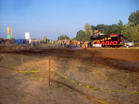 1976 Ford F-100 - Mud pit event with a truck labeled 'Pirate Radio' and spectators in the background.