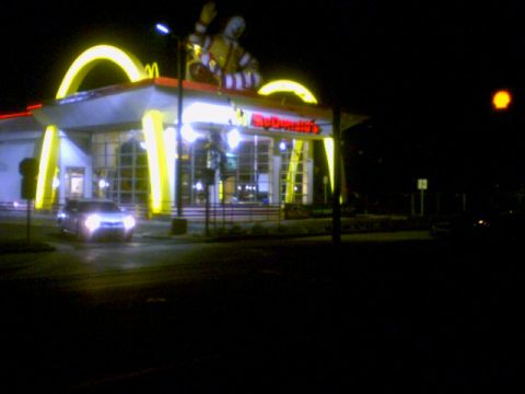 1973 Ford Ranchero - McDonald's restaurant illuminated at night with a car in the foreground.