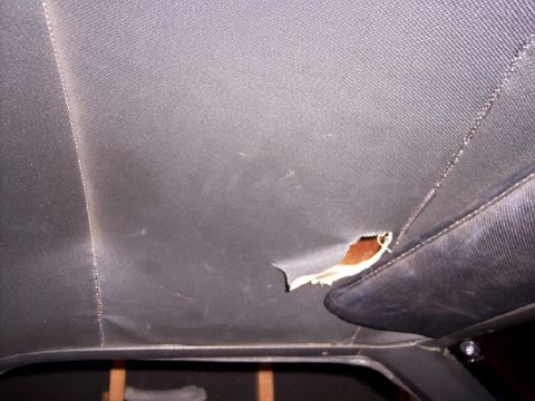 1972 Ford Ranchero - Interior view of a vehicle showing significant damage to the headliner and seat.
