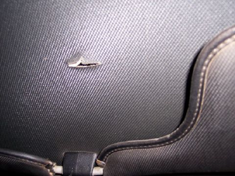 1972 Ford Ranchero - Close-up of damaged black upholstery, showing a tear and the texture of the material.