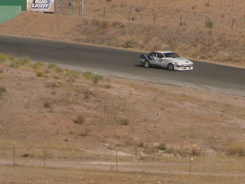 Race car cornering on a desert road course track