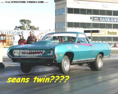 1970 Ford Ranchero - A teal 1970 Ford Ranchero drag car with a custom shark-tooth grille is captured on the race track.