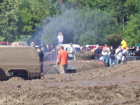 1979 Ford Bronco - Off-road vehicles stuck in mud during a bogging event with spectators present.