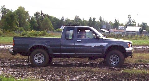 1979 Ford Bronco - This pickup truck navigates a muddy terrain, kicking up dirt as it moves.