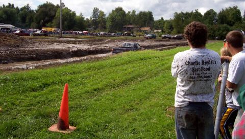 1979 Ford Bronco - Spectators watch trucks navigate a mud bog during an event.