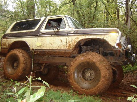 1992 Ford Mustang - This heavily modified 1978 Ford Bronco navigates a muddy trail through a forest.