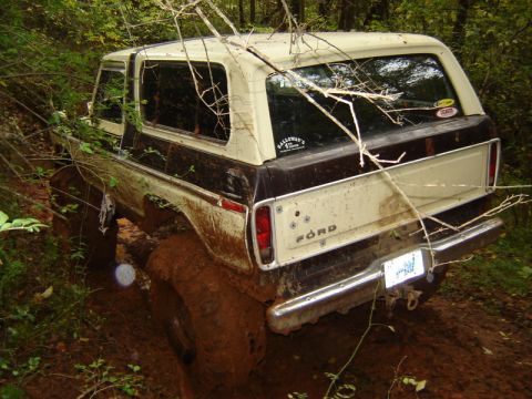 1992 Ford Mustang - Ford Bronco stuck in mud off-road, showing its rear end and side profile.