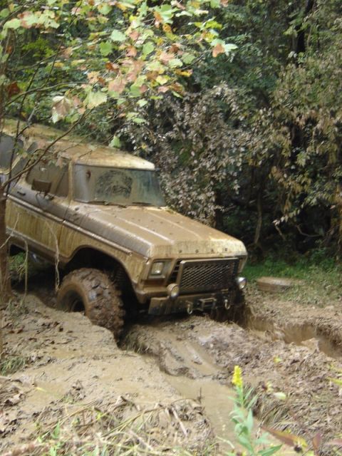1992 Ford Mustang - A heavily soiled 1978 Ford Bronco navigates a challenging off-road trail.