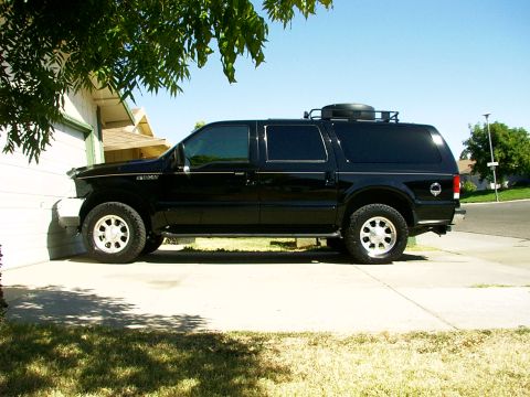 2000 Ford Excursion - A black Ford Excursion is parked in front of a house on a sunny day.
