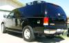 2000 Ford Excursion - Rear view of a black 2000 Ford Excursion with a roof rack and tinted windows.