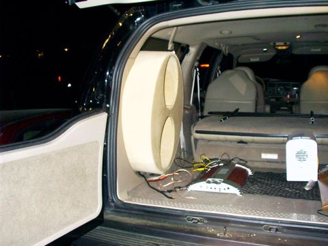 2000 Ford Excursion - The rear interior of a 2000 Ford Excursion shows a custom speaker box and audio components.