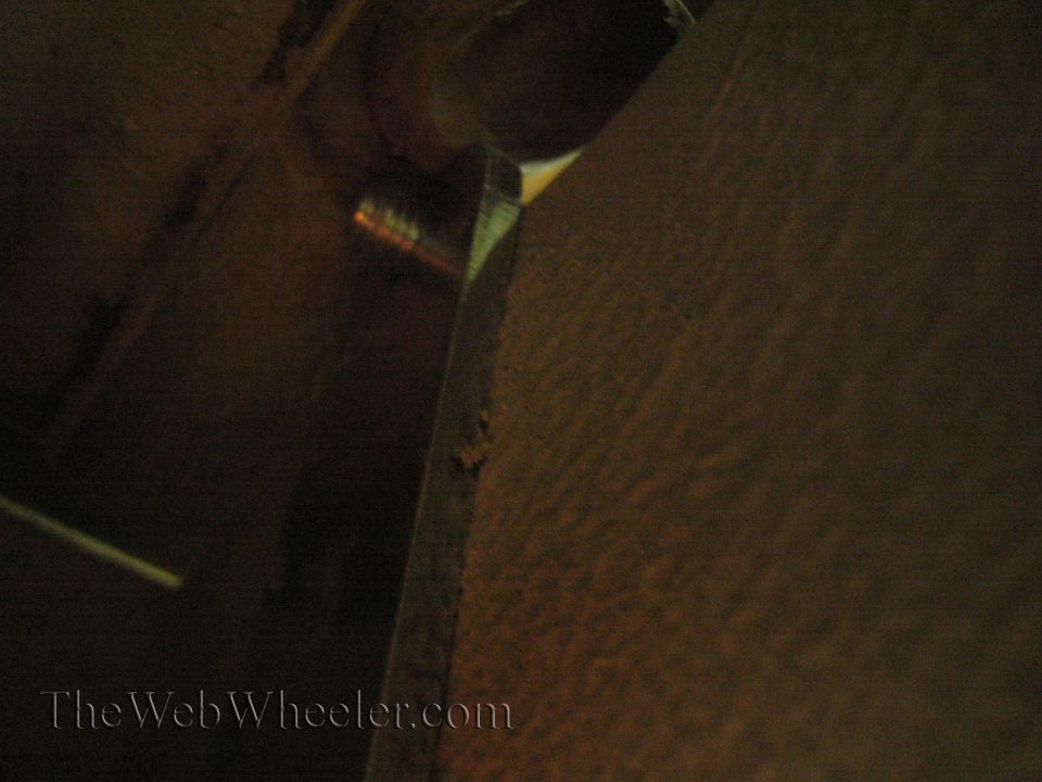 Close-up of a bolt head and textured metal surface, likely part of a vehicle's undercarriage