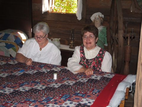 1966 Ford Ranchero - Two women are shown sewing a quilt with a pattern of American flags and stars.
