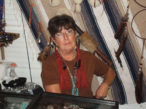 1966 Ford Ranchero - A woman wearing glasses and multiple necklaces poses in front of a tapestry.
