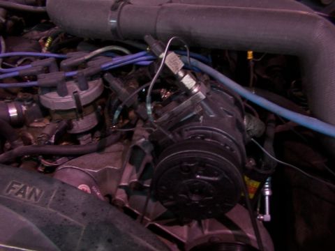 1988 Ford C-350 (Centurion Conversions) - Close-up of an engine bay, focusing on the air conditioning compressor and related engine components.
