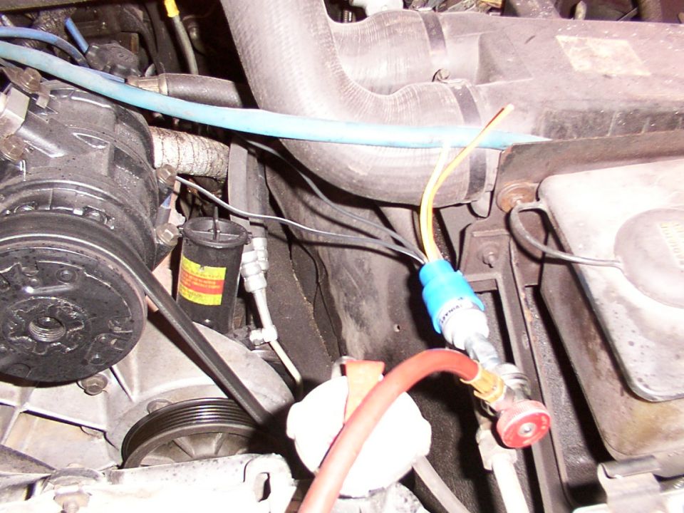 Close-up of AC system parts with hoses and gauges attached