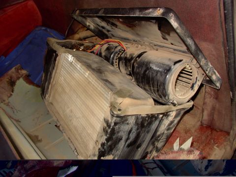 1988 Ford C-350 (Centurion Conversions) - A dusty air conditioning unit, likely from a vehicle's interior, is shown with its fan and evaporator exposed.