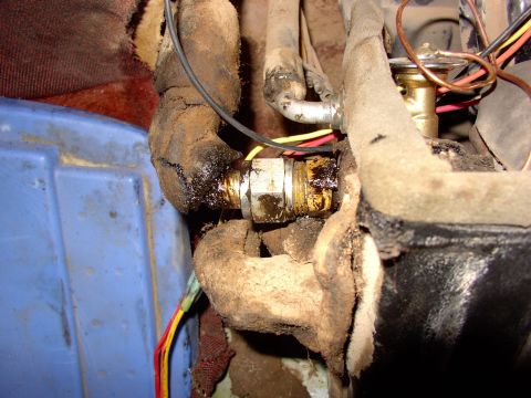 1988 Ford C-350 (Centurion Conversions) - A close-up view of a leaky air conditioning hose fitting with surrounding hoses and wiring.