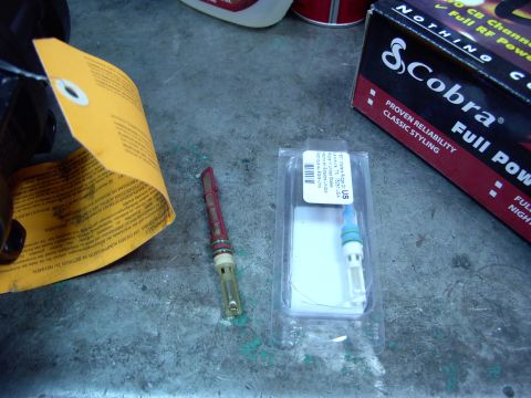 1988 Ford C-350 (Centurion Conversions) - Two AC service parts, a valve and a valve core tool, are laid out next to a Cobra CB radio box.